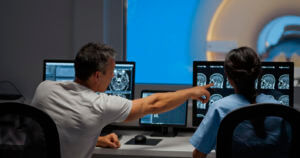 Male and female MRI radiologists sitting in the control room
